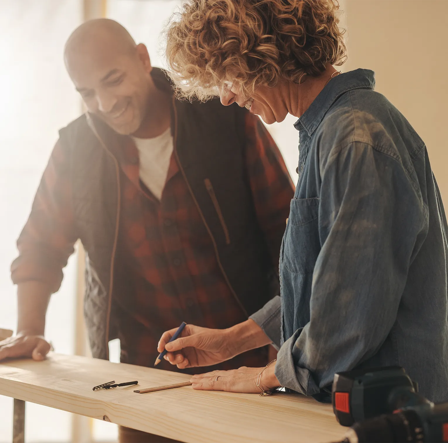 couple-measuring-wooden-board
